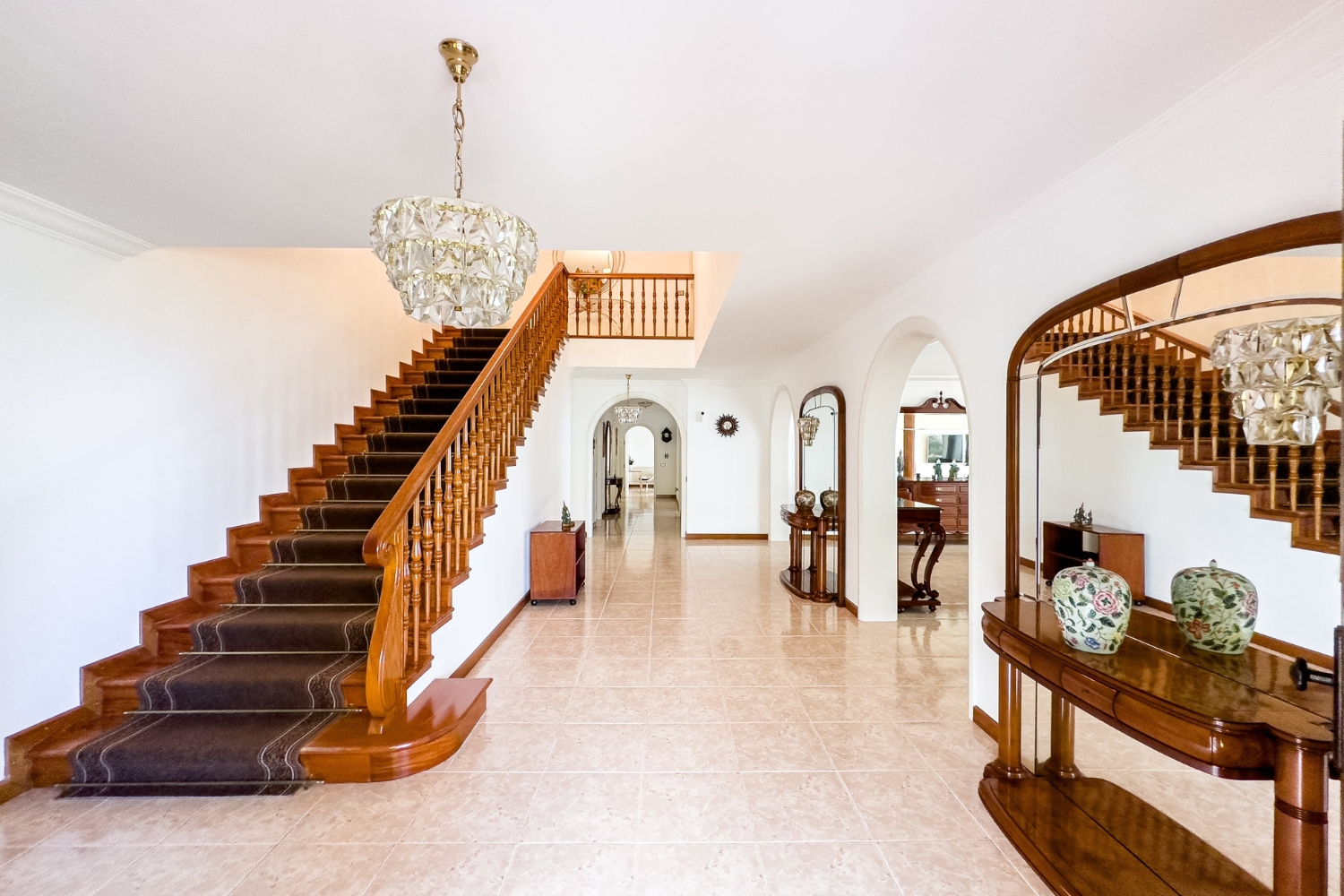 Holul interior al vilei, cu scară elegantă și candelabre